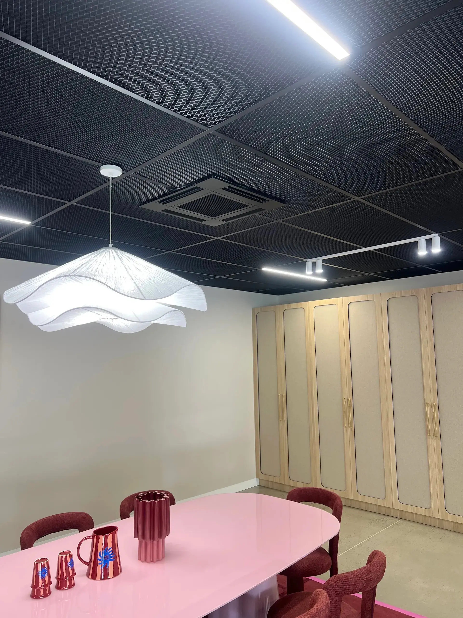 Mesh ceiling with integrated LED strip and track lighting installed by Hassett Electrical in Rosebery