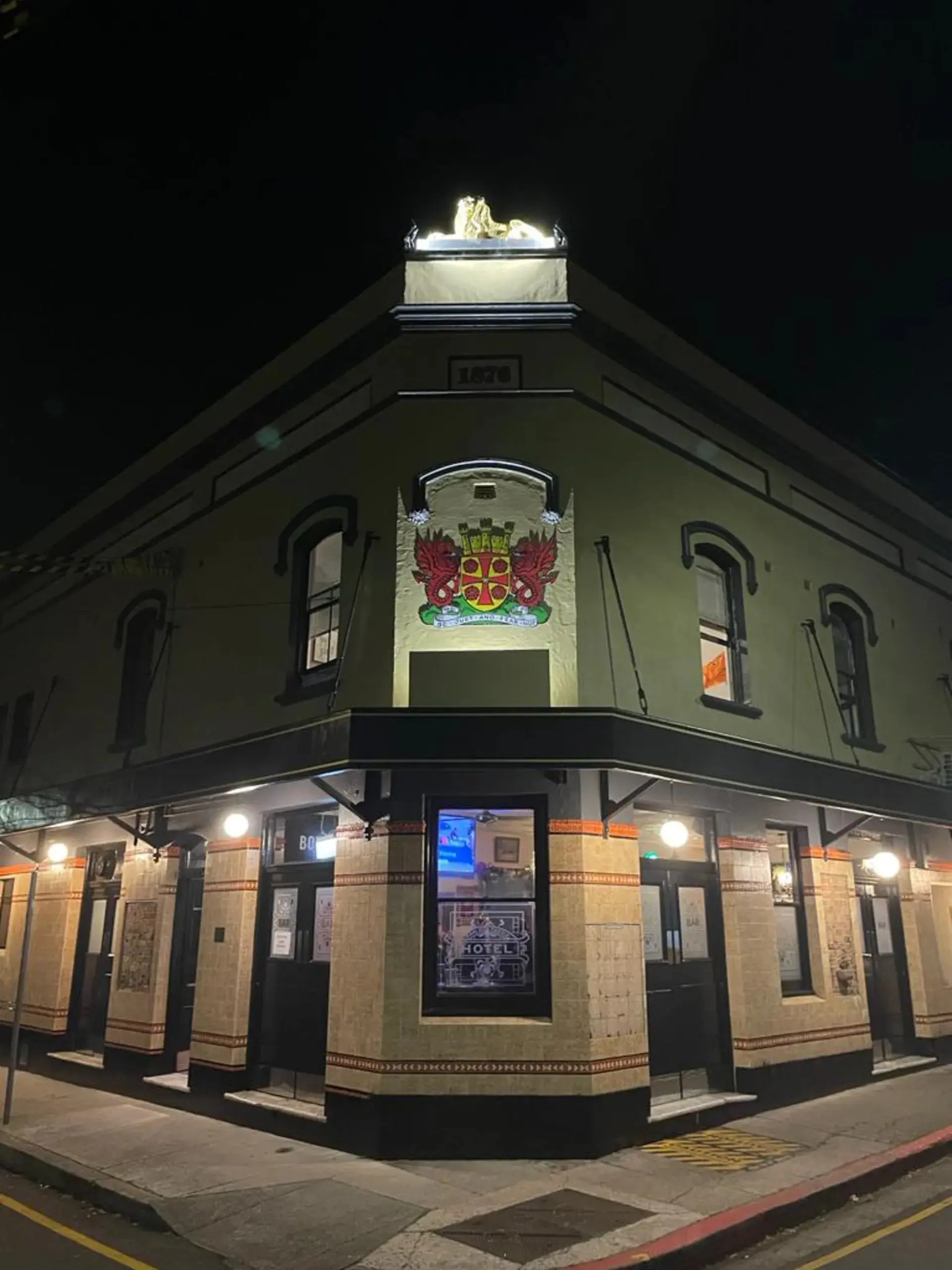 Illuminated heritage crest and facade lighting at the Carlisle Castle Hotel, Newtown — commercial lighting installation by Hassett Electrical