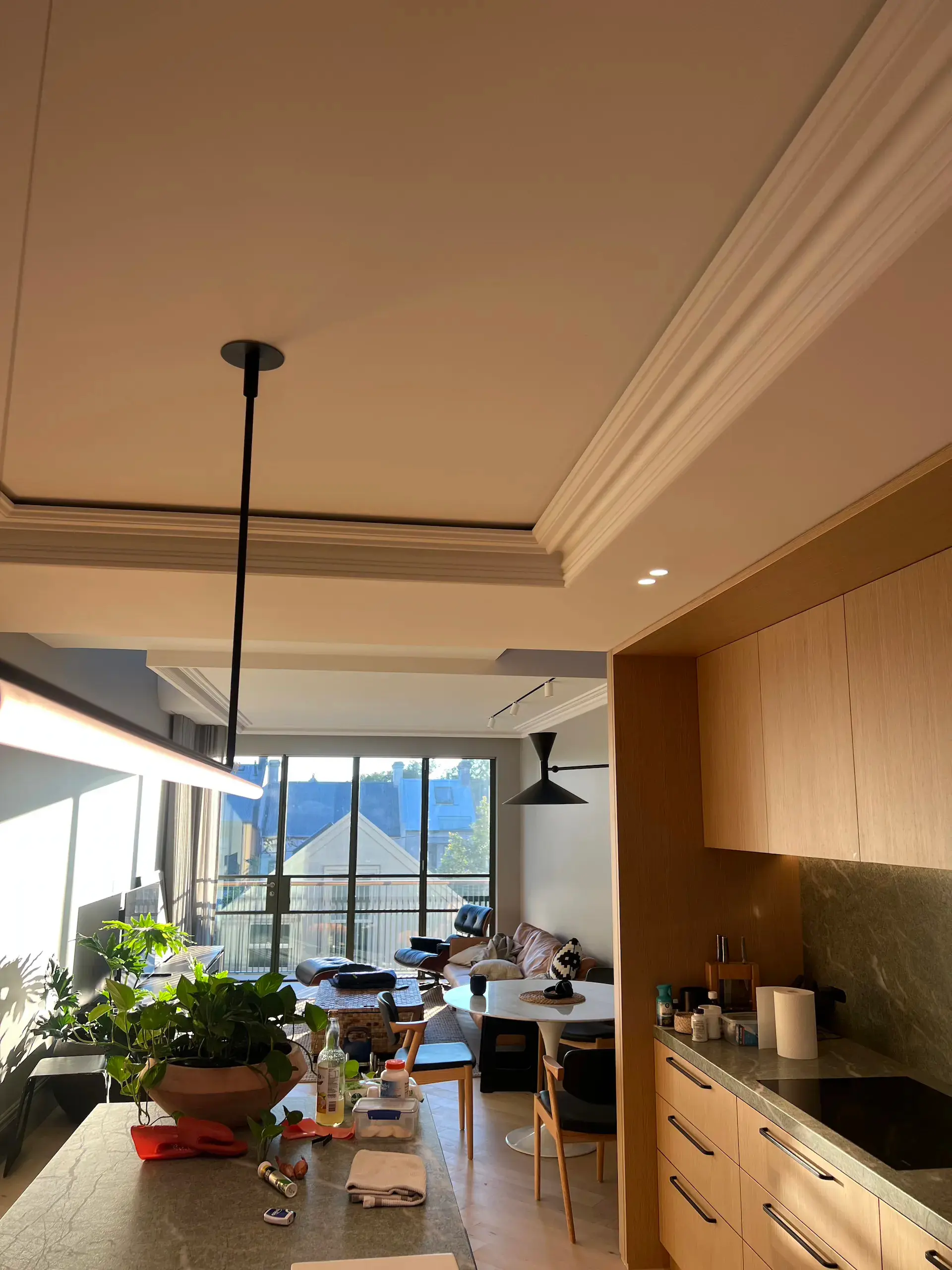Open-plan kitchen and living area lighting installation in a Paddington home, featuring pendant, track and wall lights